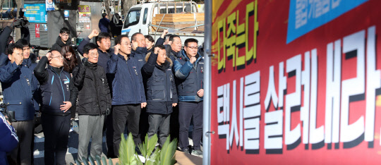 지난 10일 '카카오 카풀'에 반대하며 분신해 사망한 택시기사 최모 씨의 분향소가 12일 국회 앞에 설치돼 택시단체 회원들이 구호를 외치고 있다.  연합뉴스